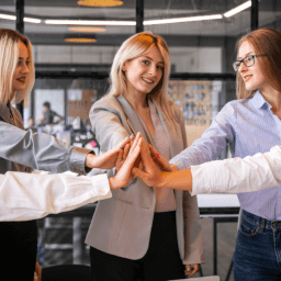 women in office joining hands