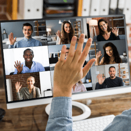 a desktop display with people in an online meeting raising their hands