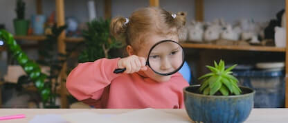 child looking through a magnifier