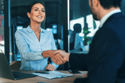 woman and man sitting in an office shaking hands